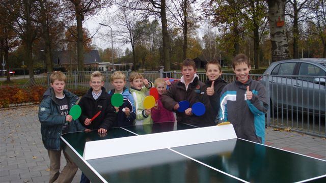 Groene betonnen pingpongtafel met afgeronde hoek en kinderen 